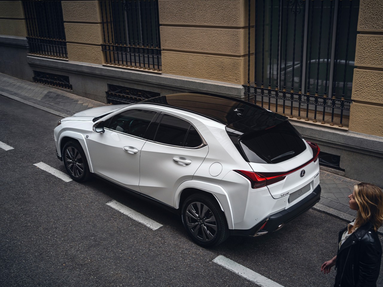 A woman walking towards a Lexus UX 