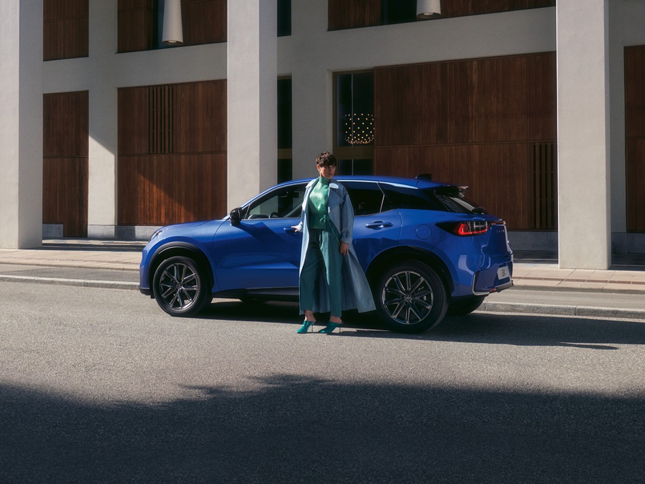 Osoba stojaca vedľa vozidla Lexus LBX