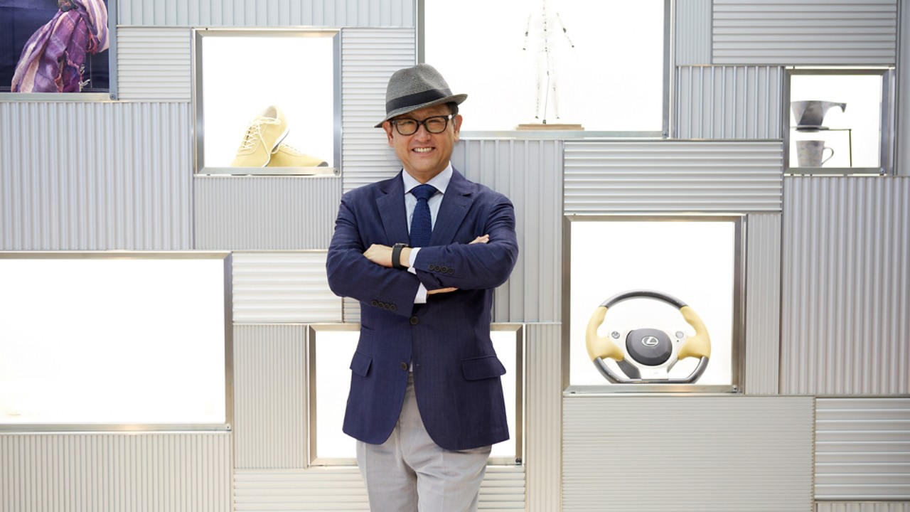 Usmievavý Akio Toyoda v obleku a klobúku