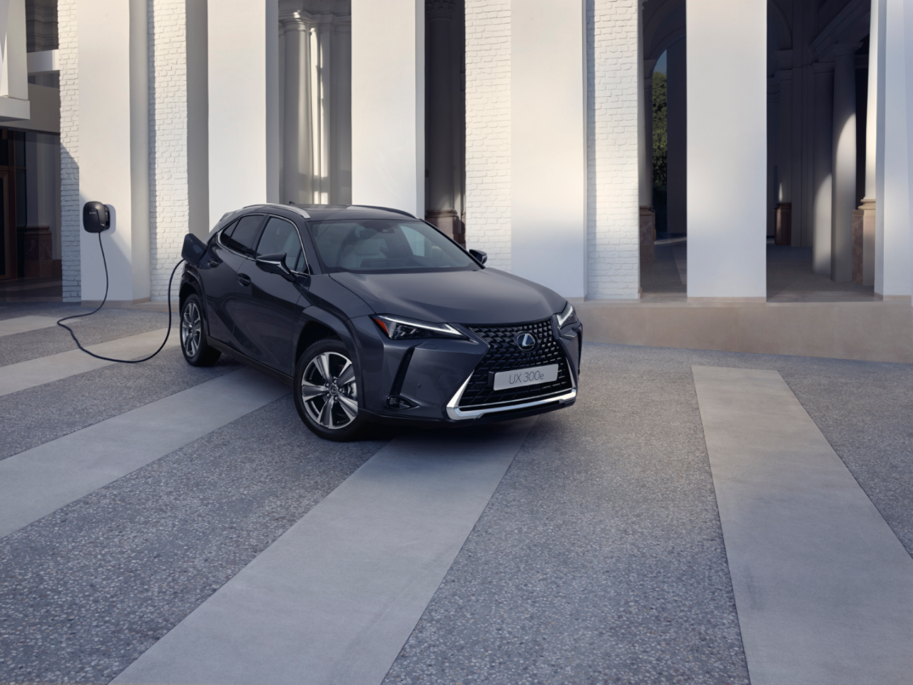 A Lexus UX 300e plugged into a charging wallbox